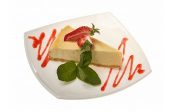 A slice of cheesecake with strawberries and mint on a white plate