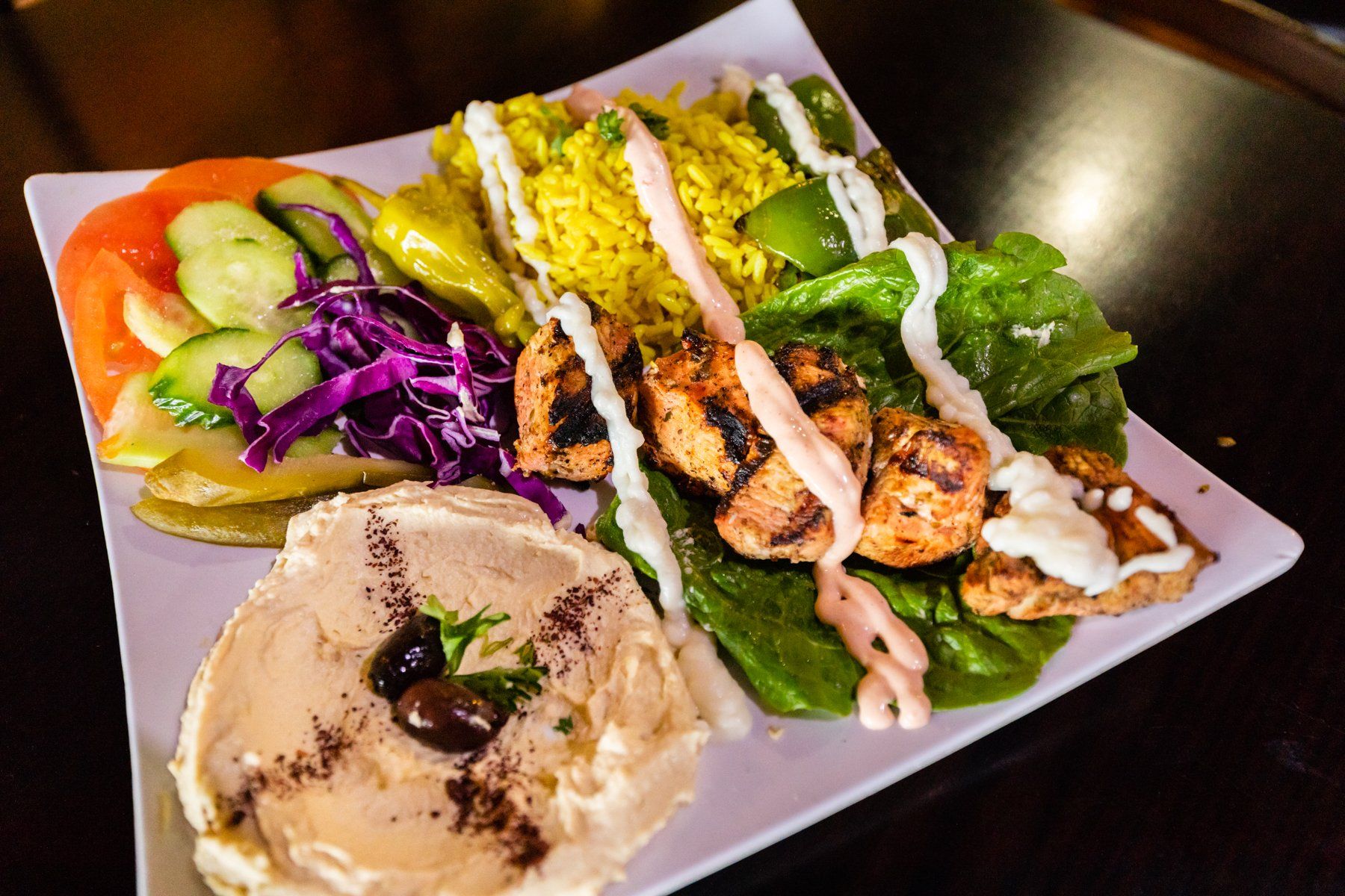 A plate of food with hummus and rice on a table
