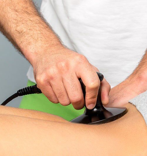 Applying Electrotherapy On Female Spine — Chiropractic Clinics in Madisonville, TN