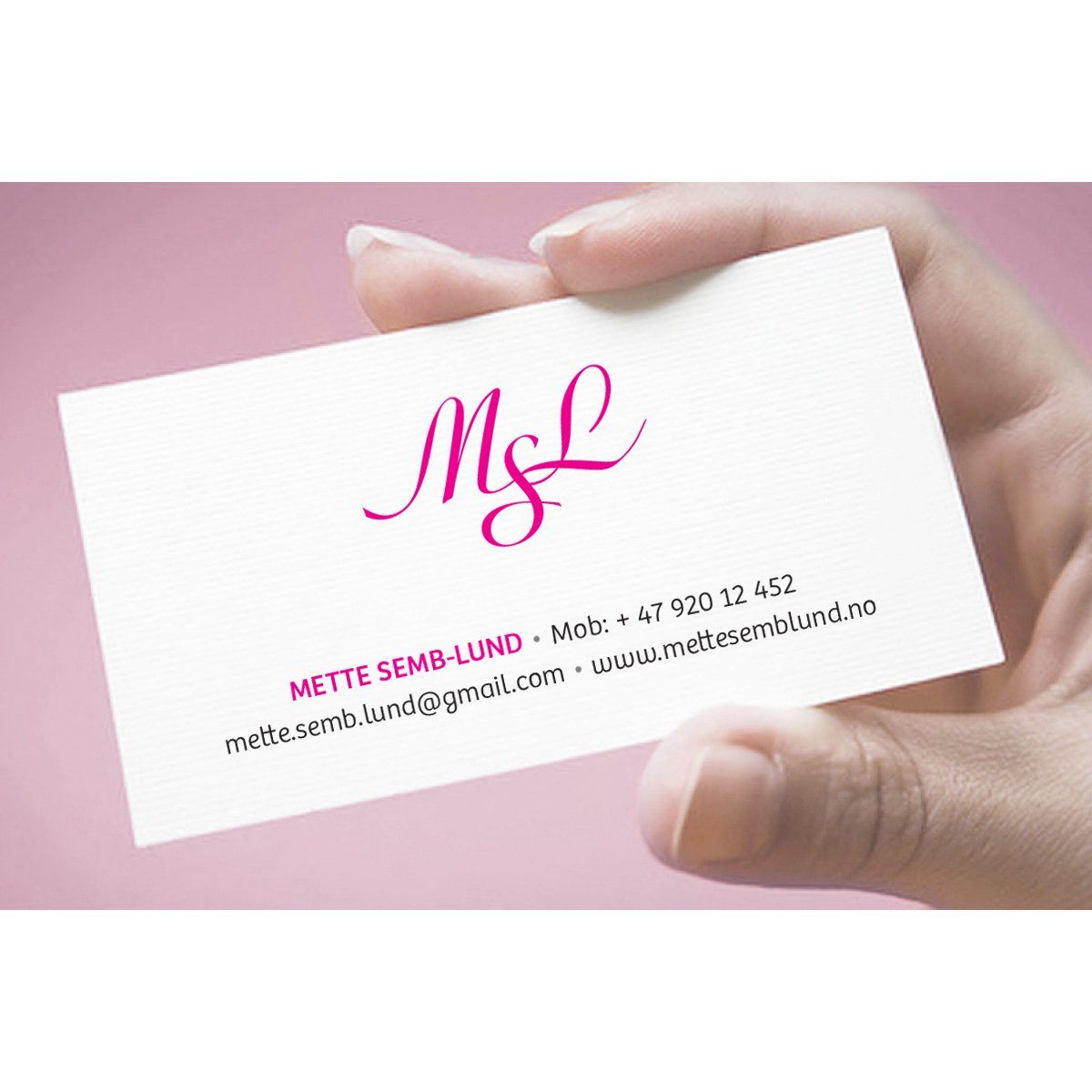 En person holder et visittkort som sier m & l