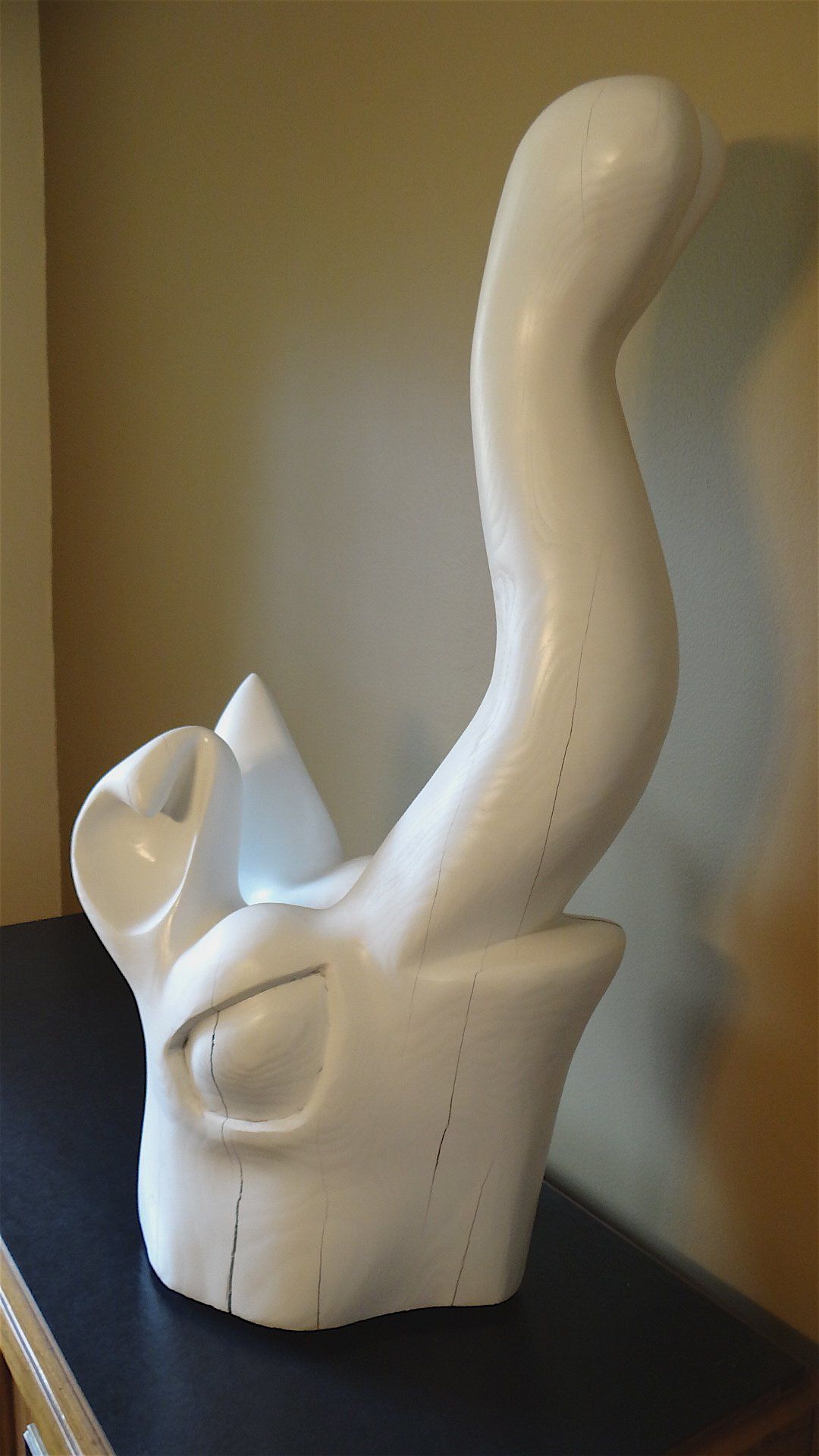 A white sculpture is sitting on a black table.