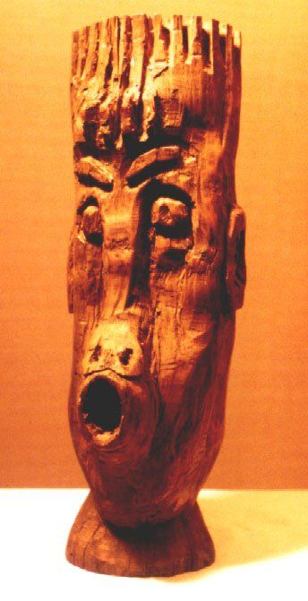 A wooden sculpture of a man 's head with a crown on it