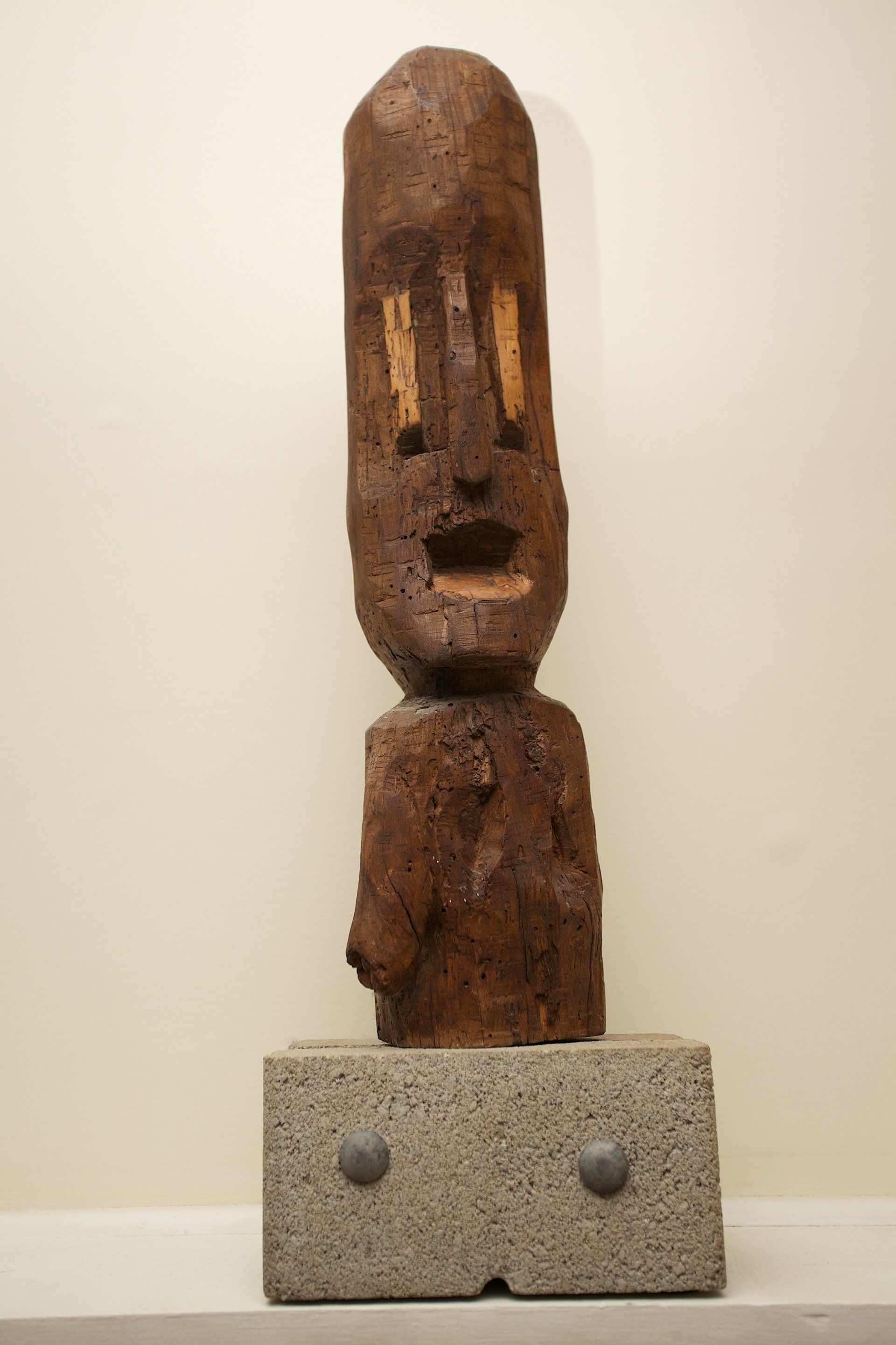 A statue of a man 's head is sitting on a shelf.