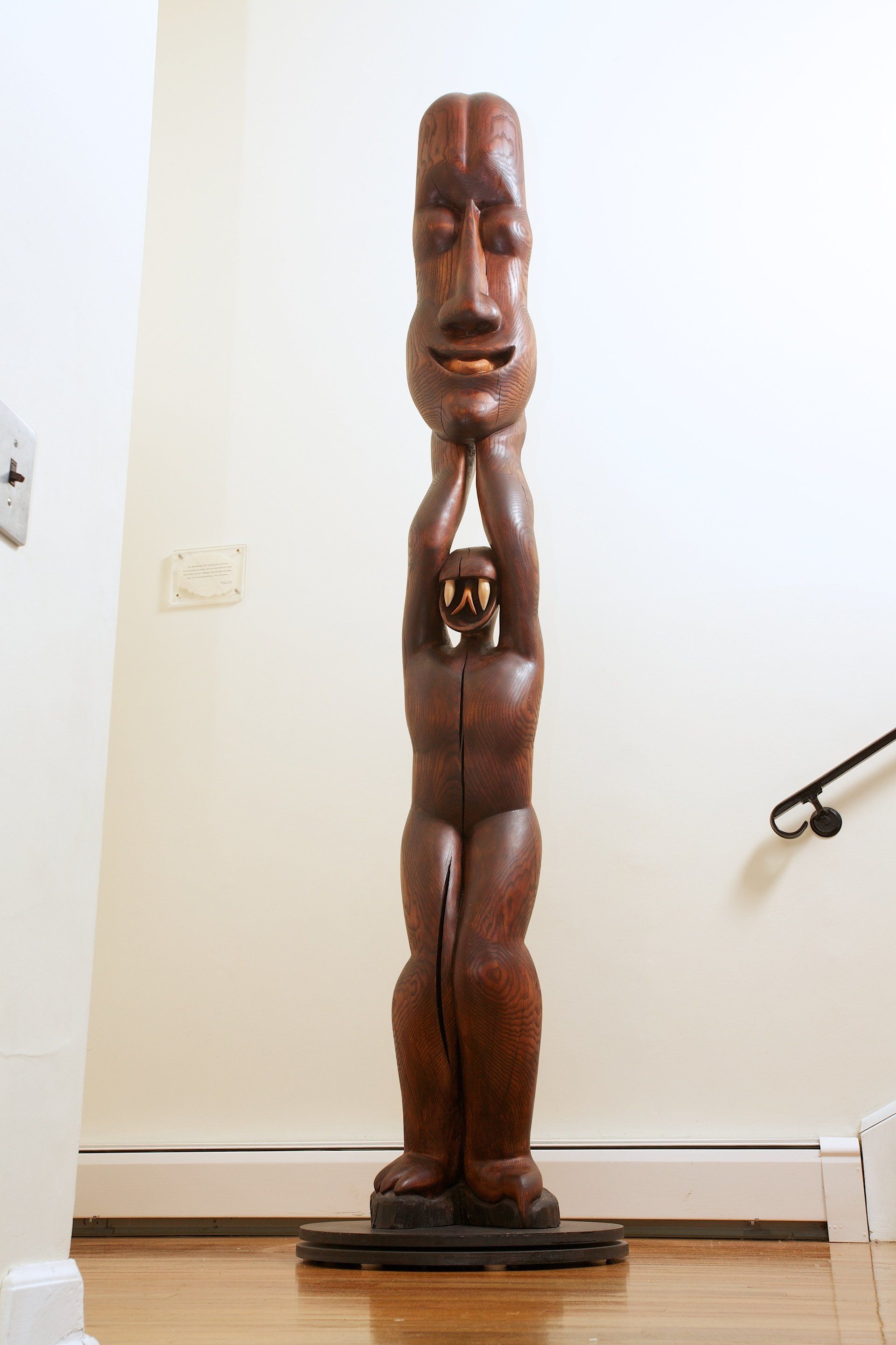 A wooden statue of a man holding a child on his shoulders