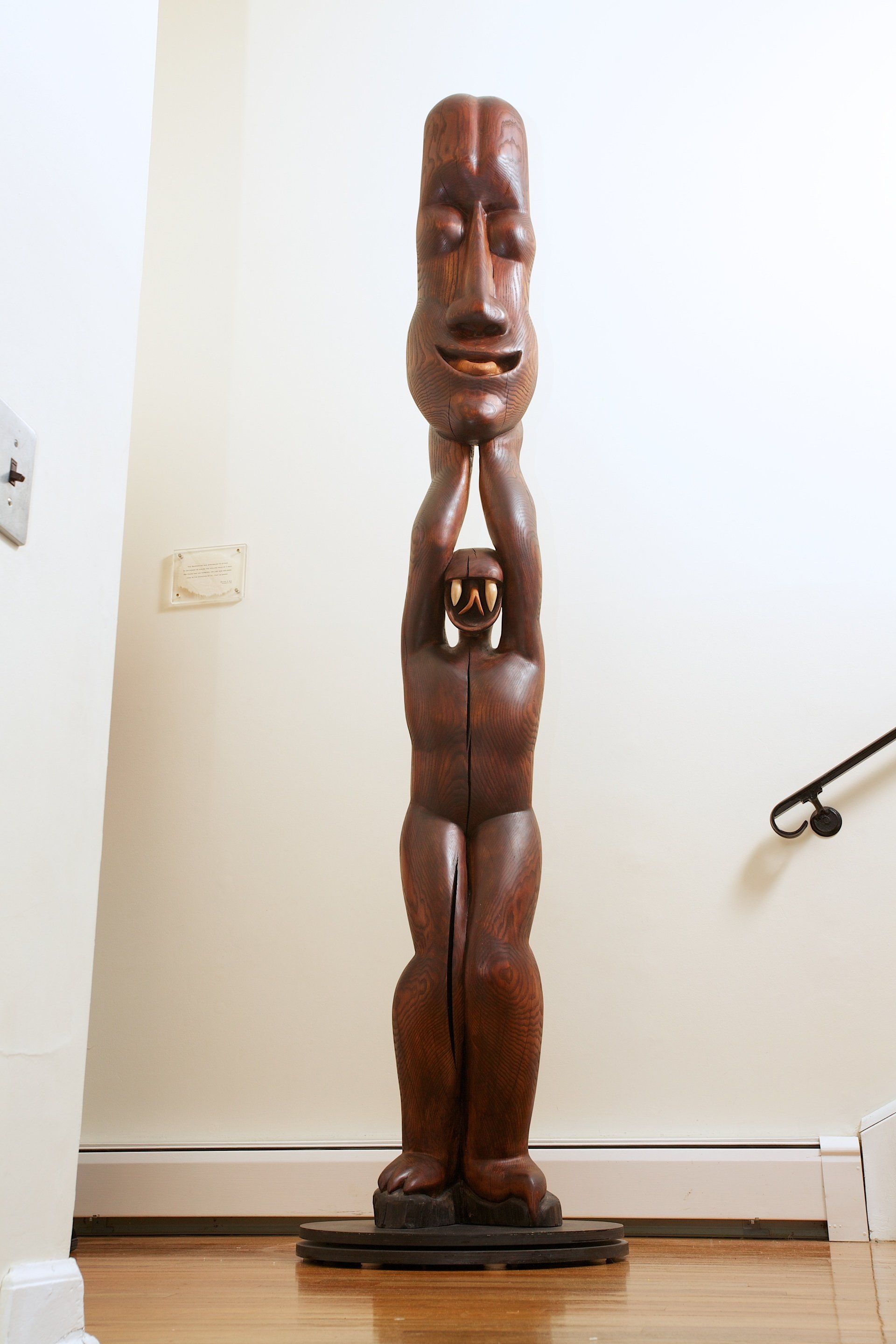 A wooden statue of a man with his hands folded