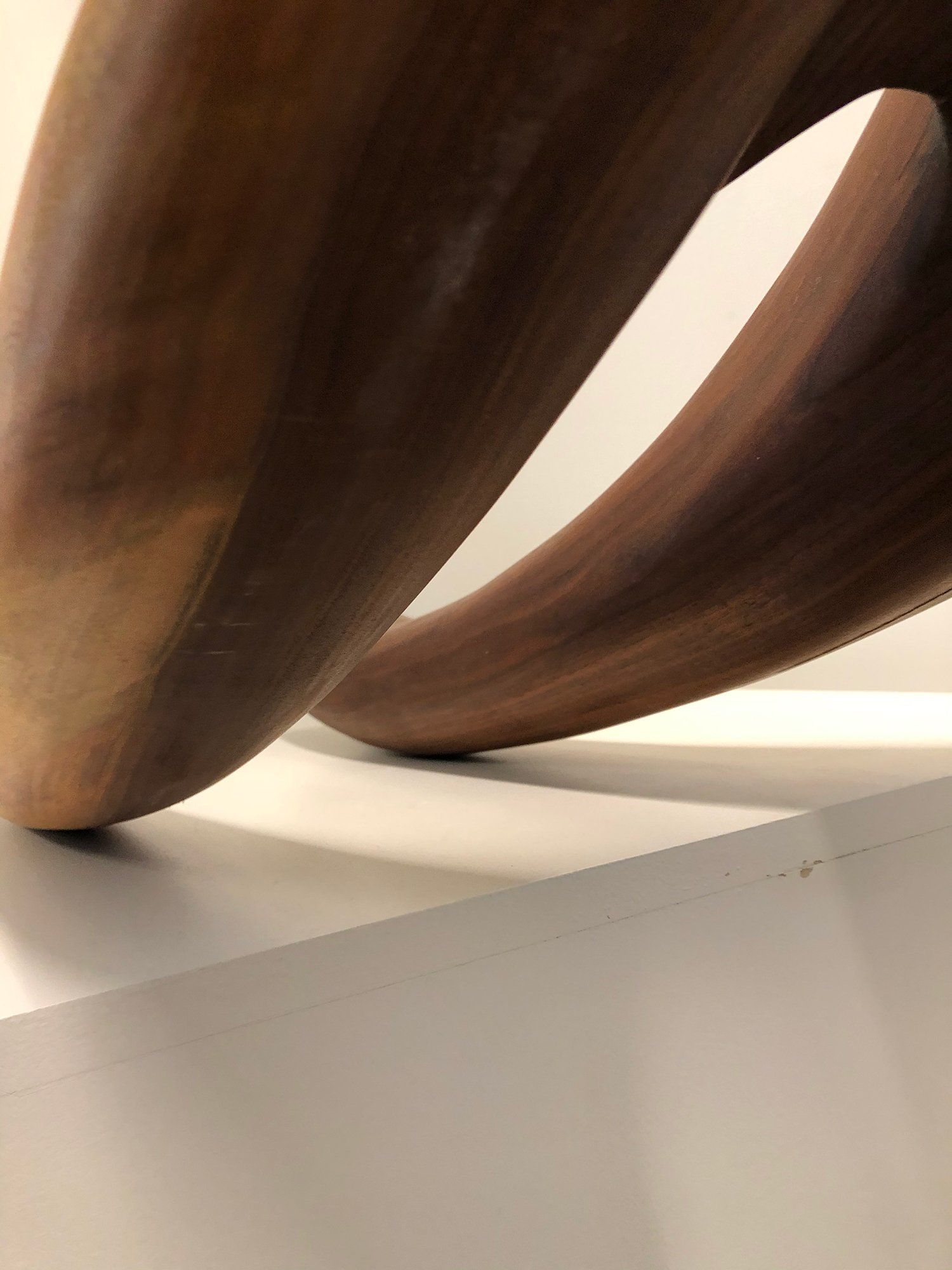 A close up of a wooden sculpture on a white surface