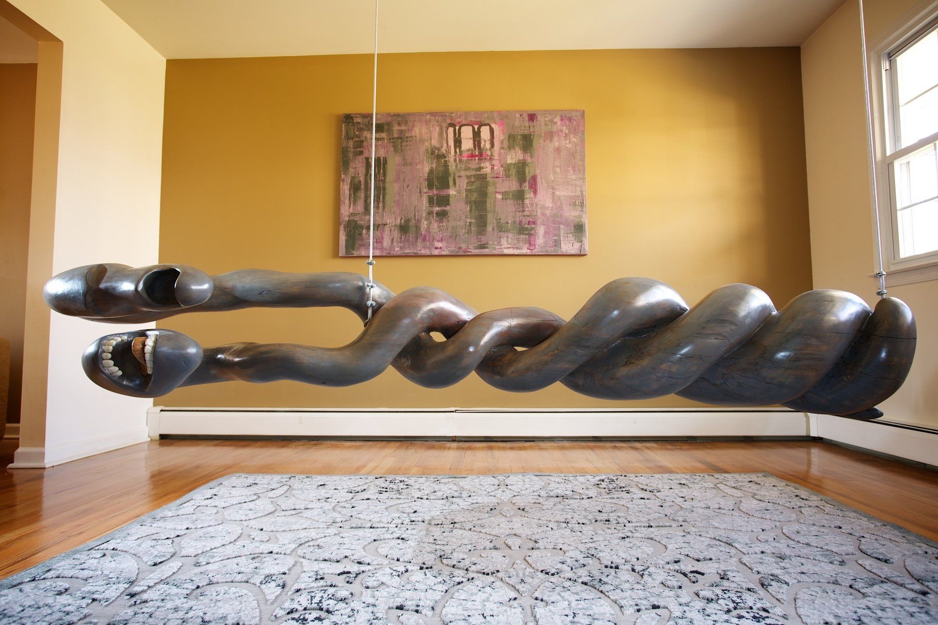 A large sculpture is hanging from the ceiling in a living room