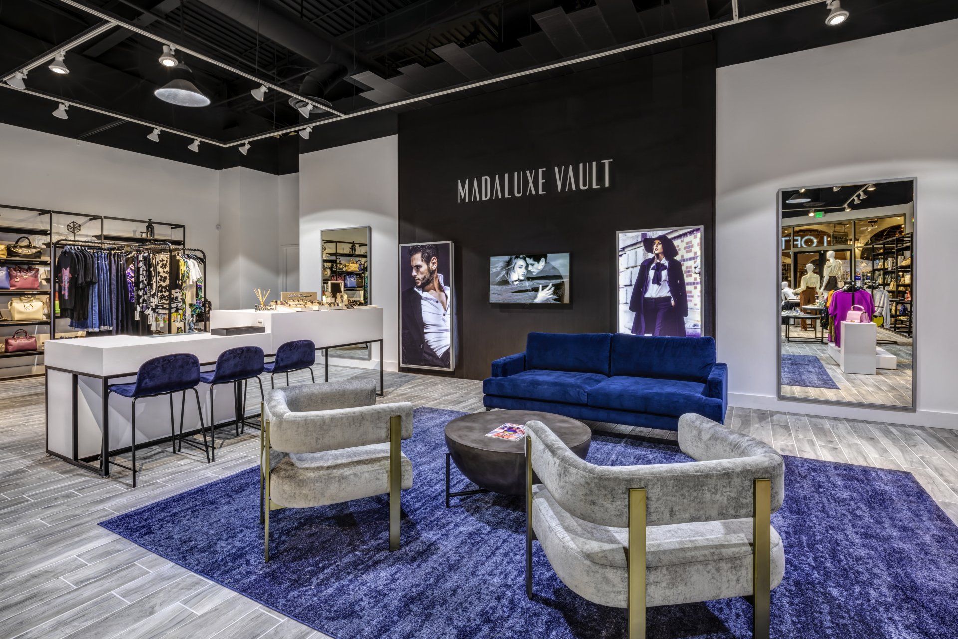 A living room with a blue couch and chairs in a store.