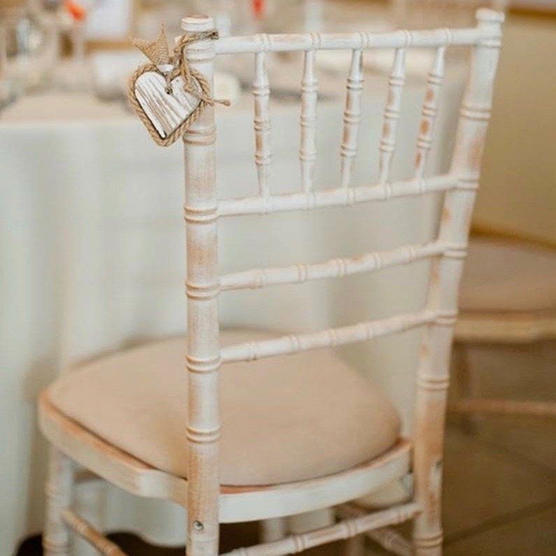 A white chair with a heart tag hanging from the back of it.