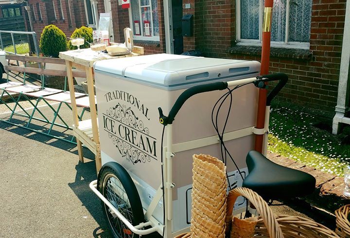 A bicycle with an ice cream cart attached to it.
