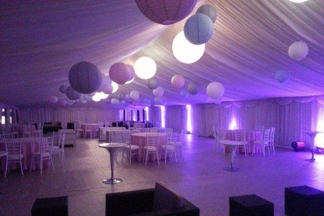 A large room with tables and chairs and purple lights