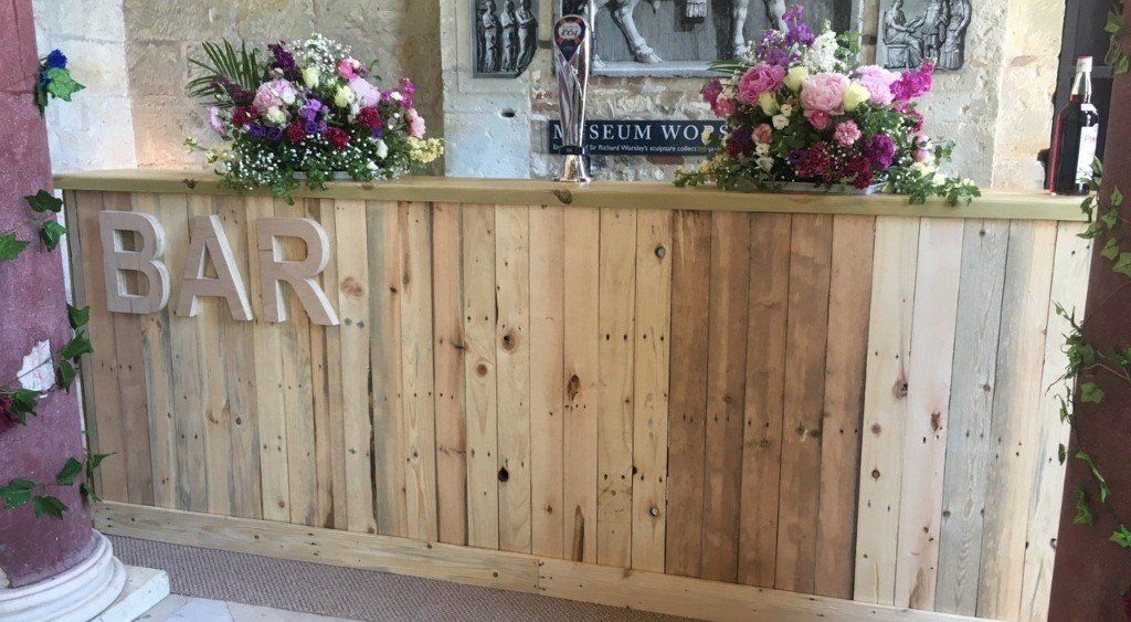 A wooden bar with flowers on top of it.