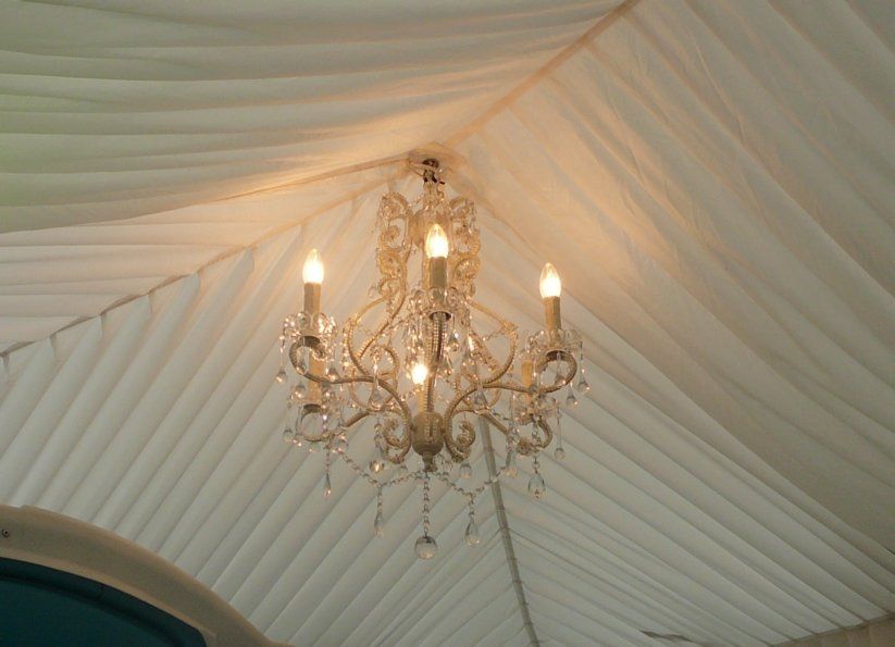 A chandelier is hanging from the ceiling of a tent