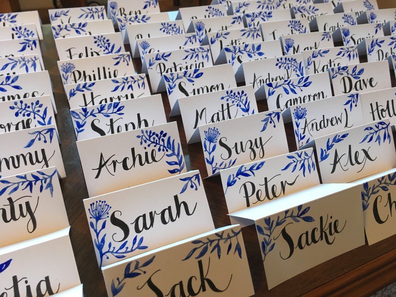 A row of place cards with the names sarah and sackie on them