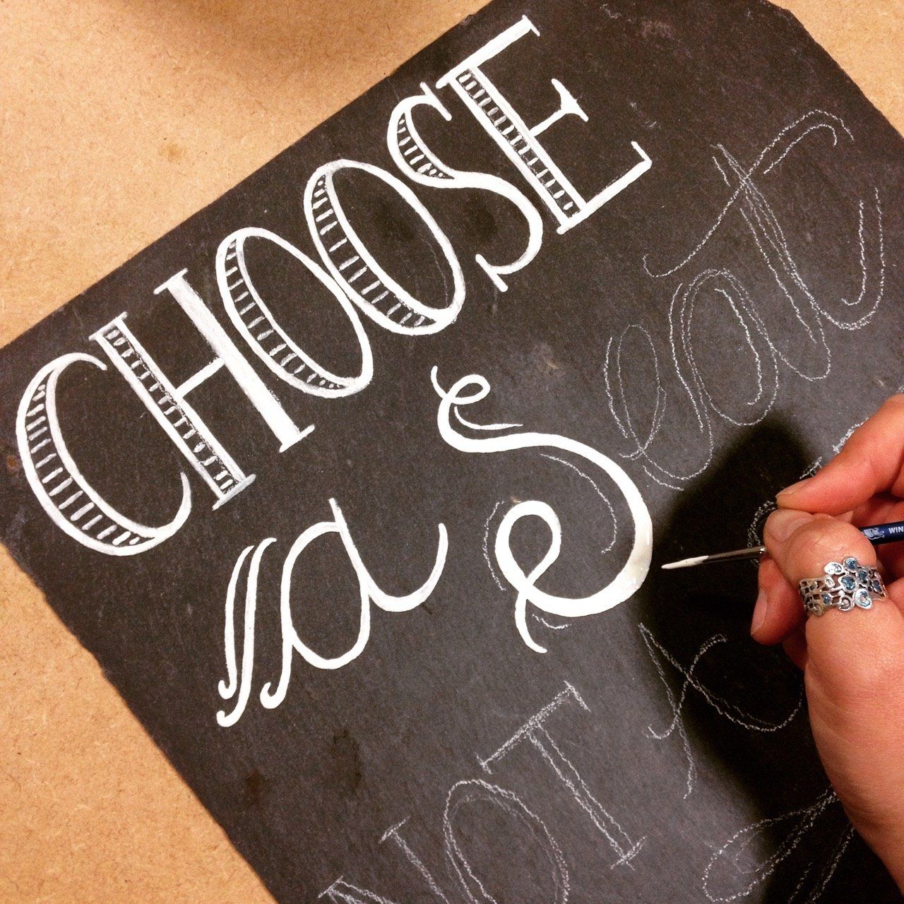 A person is writing on a chalkboard that says