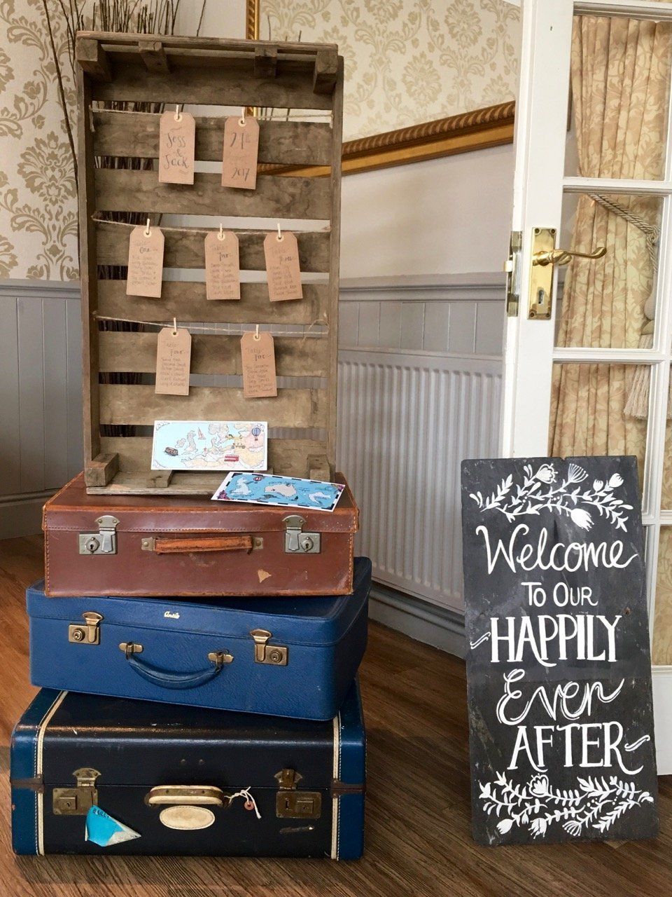 A stack of suitcases sitting next to a sign that says welcome to our happily ever after.