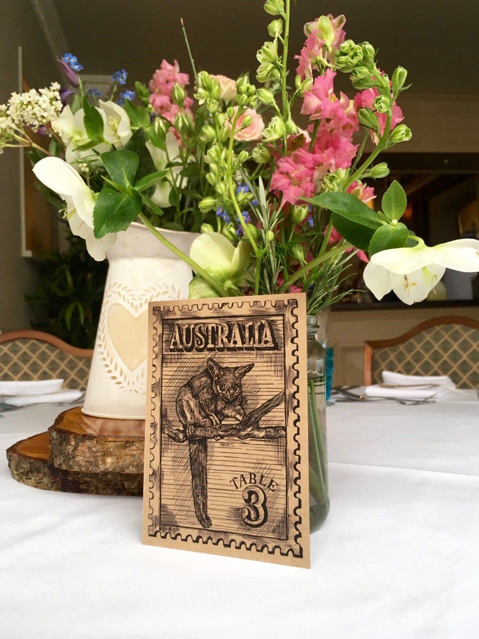 A table with a vase of flowers and a sign that says australia