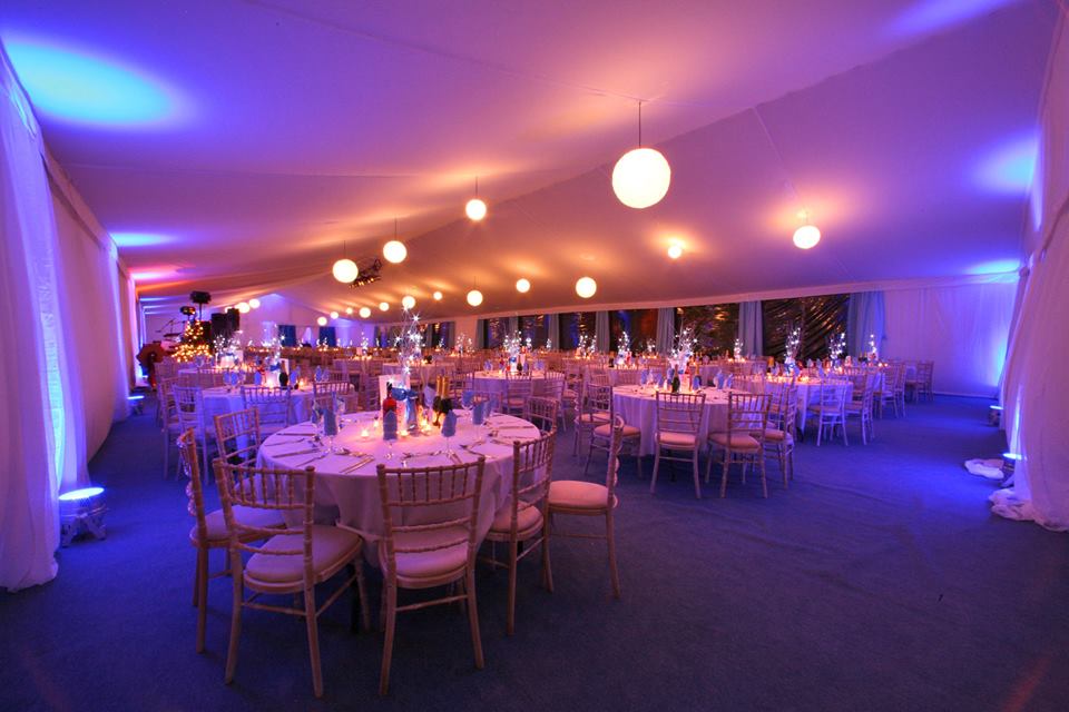 A large room with tables and chairs set up for a party.