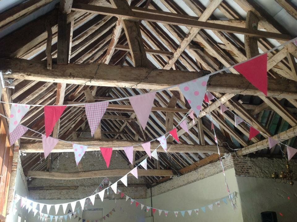 A bunch of flags are hanging from the ceiling of a building