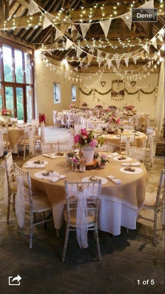 A large room with tables and chairs set up for a wedding reception.