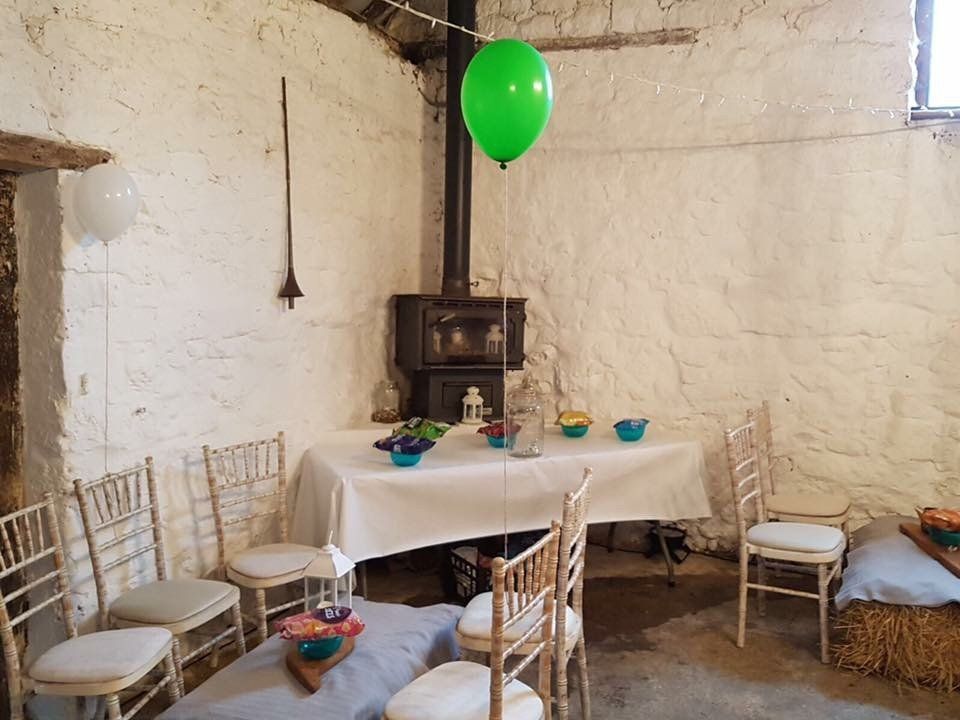 A room with a table and chairs and a green balloon hanging from the ceiling.