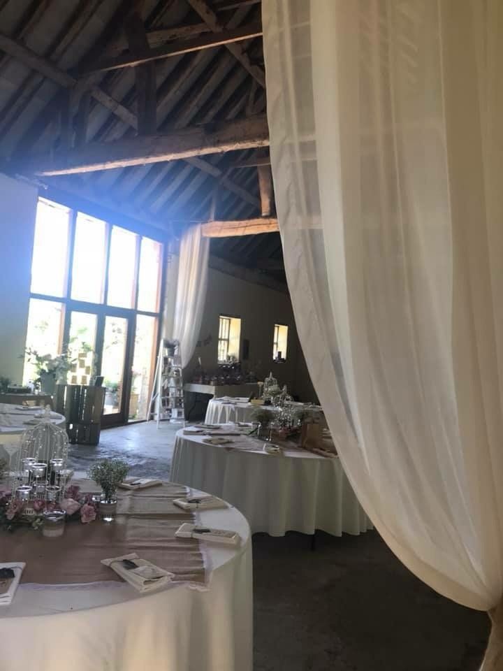 A large room with white tables and white curtains