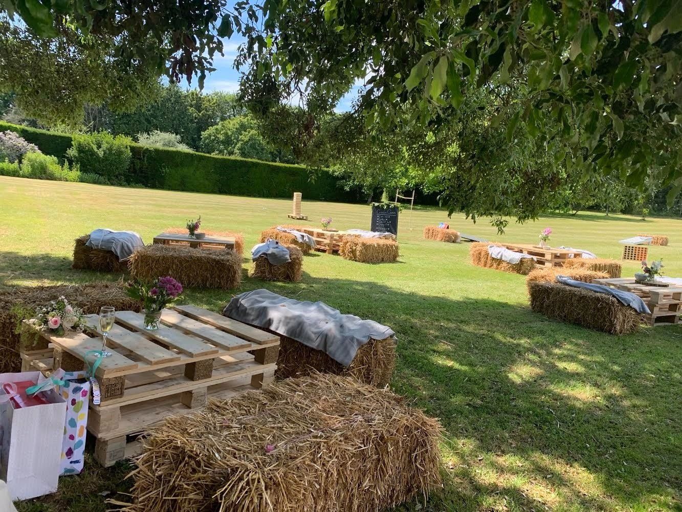 A field filled with hay bales and wooden pallets.