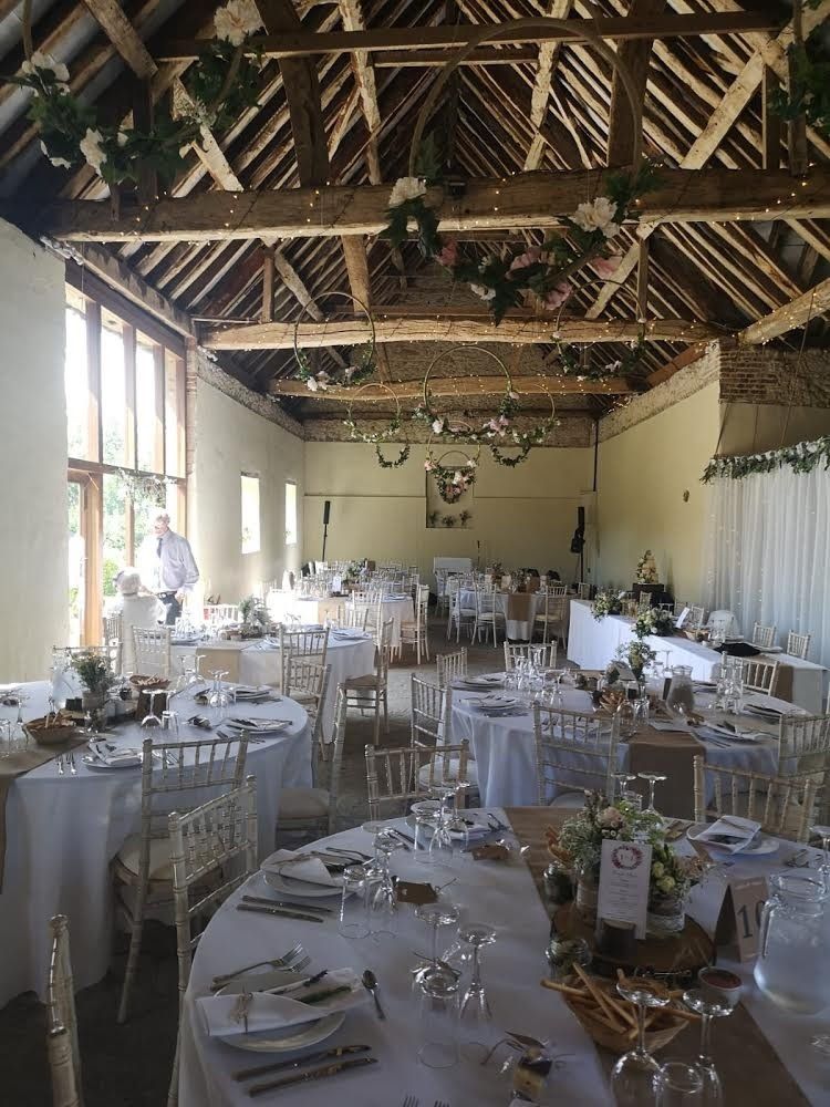 A large room with tables and chairs set up for a wedding reception.