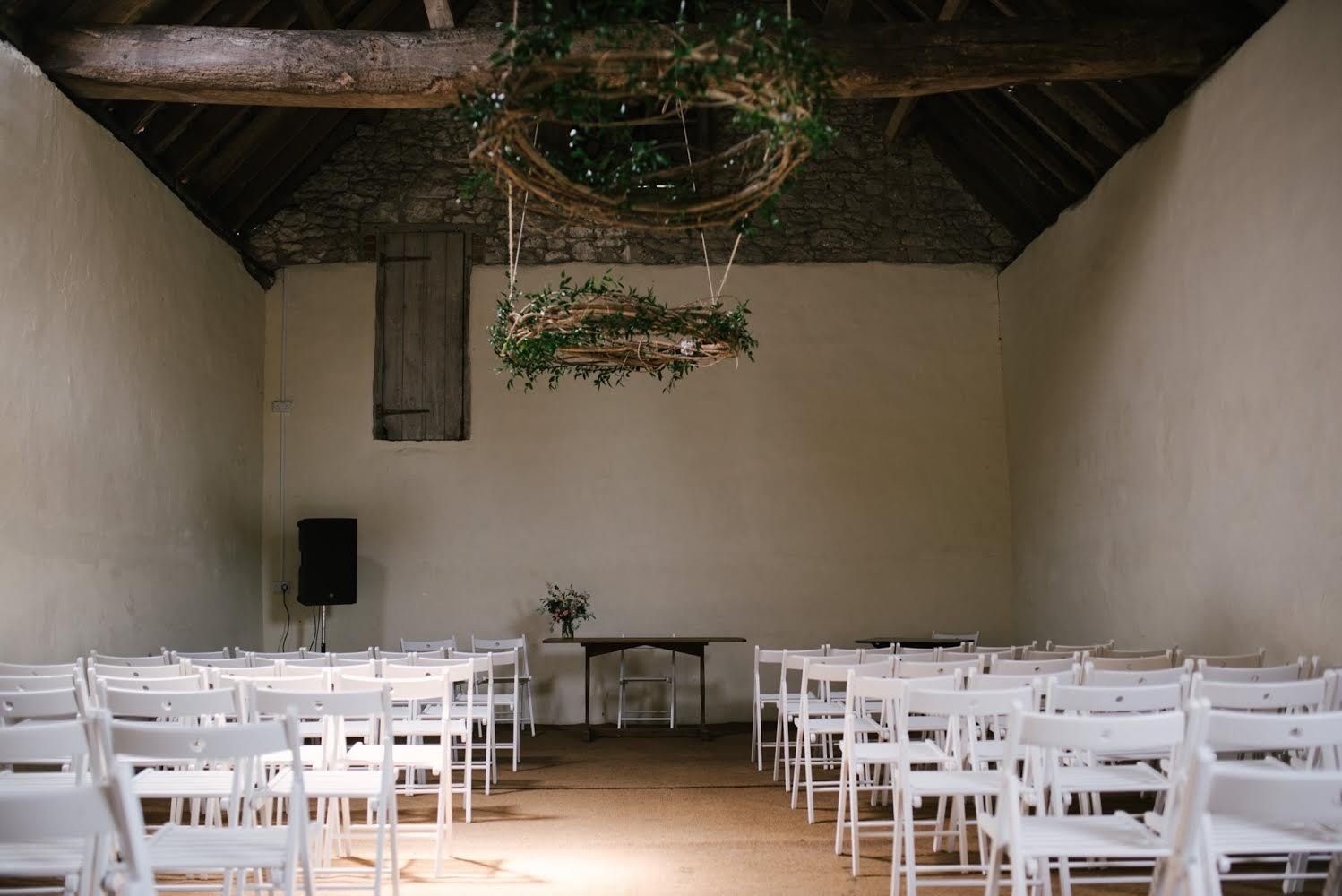 A row of white folding chairs are lined up in a room.