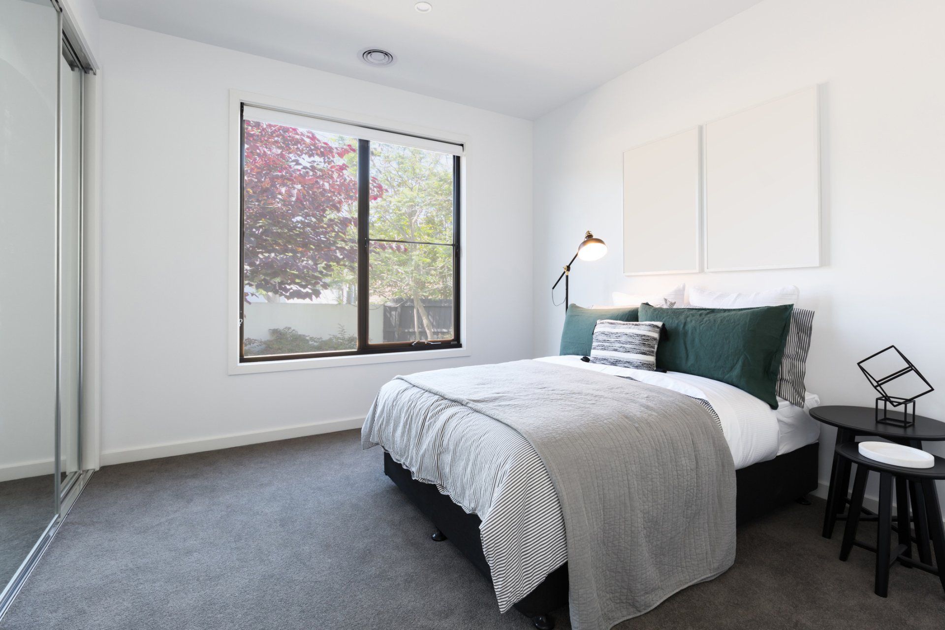 fully carpeted bedroom with nightstand and window