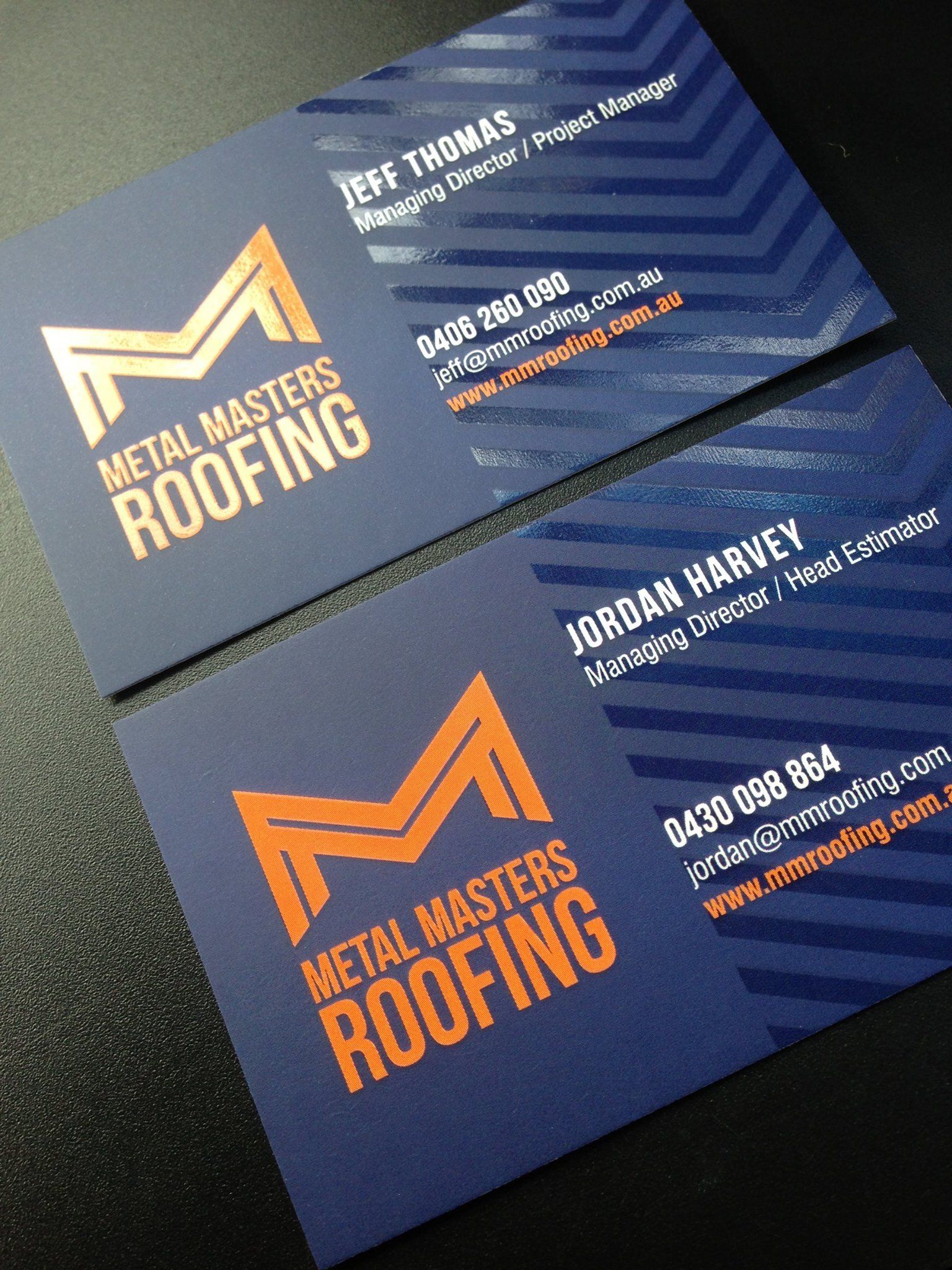 Two navy blue business cards with orange logo 