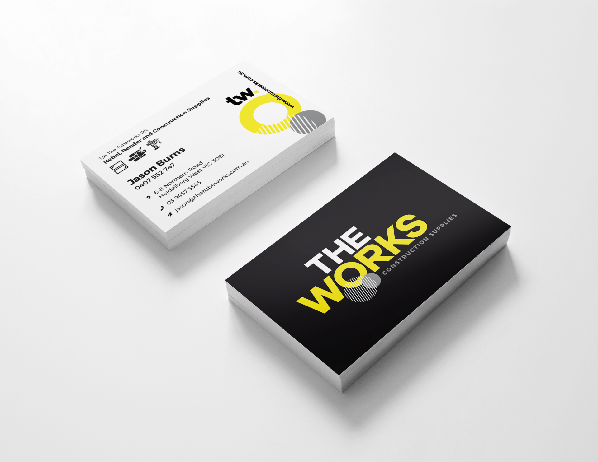Business cards stacked, black and white with yellow accents.