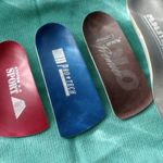 Three different colored insoles are sitting on a green cloth.
