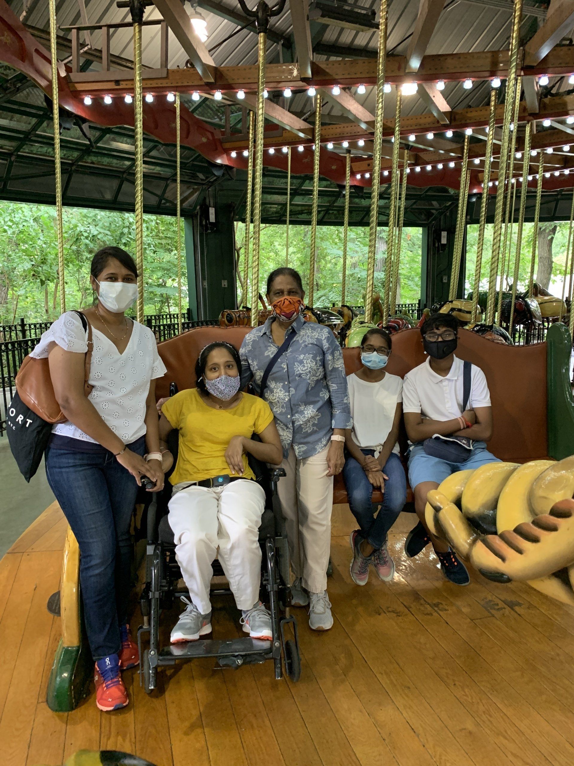 Smiling family portrait at the Bronx Zoo waiting for our first wheelchair accessible carousel ride.  