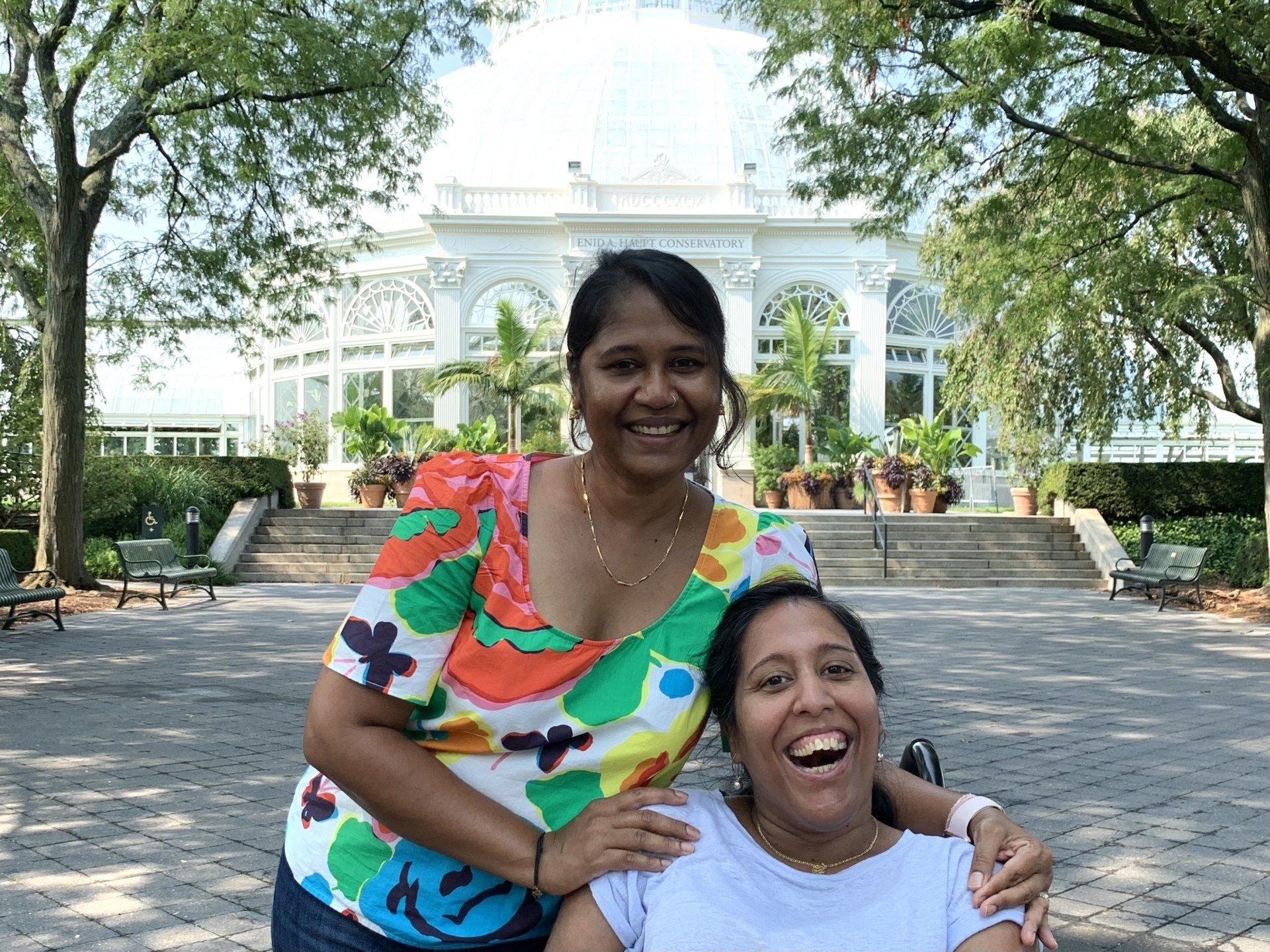 Lakshmee and Annie, all smiles, at NYBG with the Conservatory in the background.