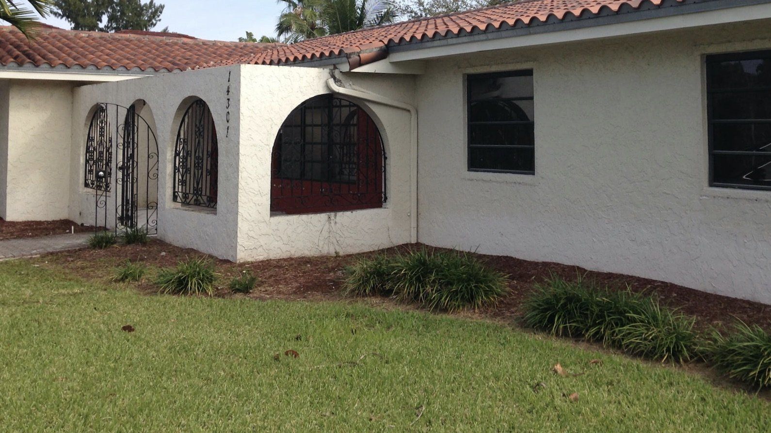 a white house with a red roof and arched windows