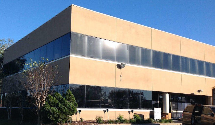 a large building with a lot of windows and a van parked in front of it