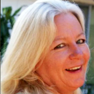 Close-up of a smiling blonde woman outdoors in warm sunlight