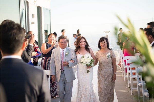 A bride and groom are walking down the aisle at their wedding.