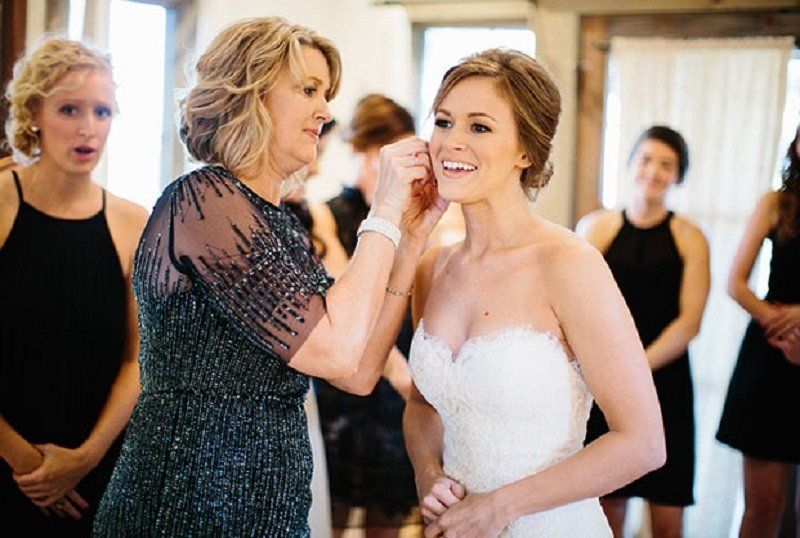 A mother of the bride is helping her daughter get ready for her wedding.
