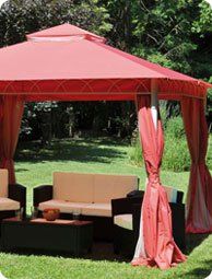 Pergola de jardin di colore rosso , sofà e due poltrone color crema .