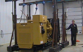 Yellow industrial machine on a platform in a warehouse, with a person standing beside it