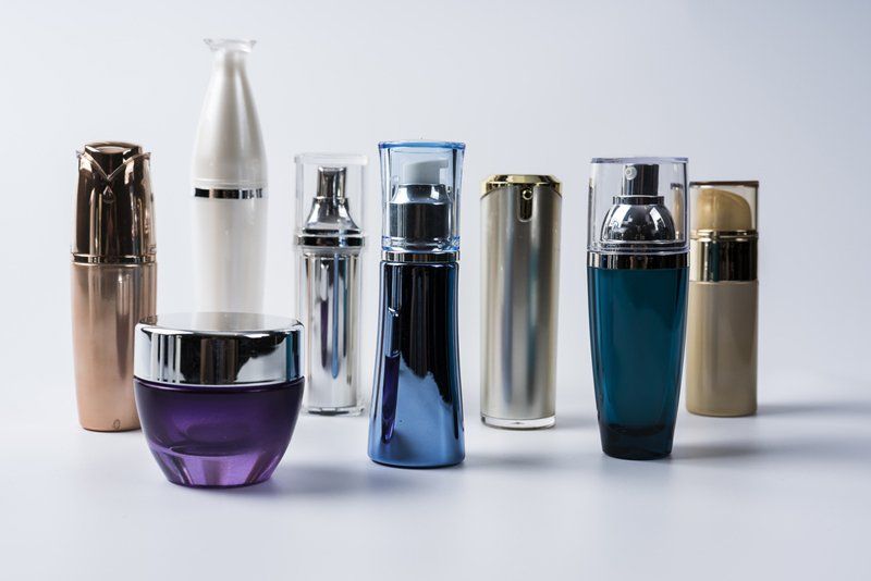 Collezione di contenitori per prodotti cosmetici di varie forme e colori.