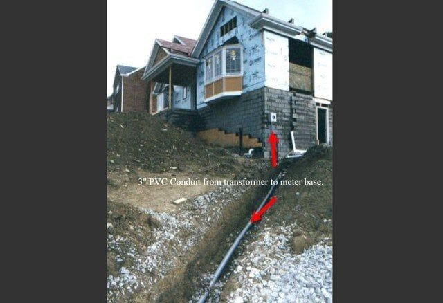 A trench with PVC conduit running to a house under construction A trench with PVC conduit running to a house under construction
