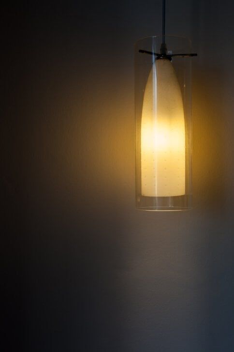 Warm glowing pendant light against a dark background