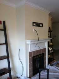 Living room with fireplace mantel, hanging cables, and a black ladder against the wall