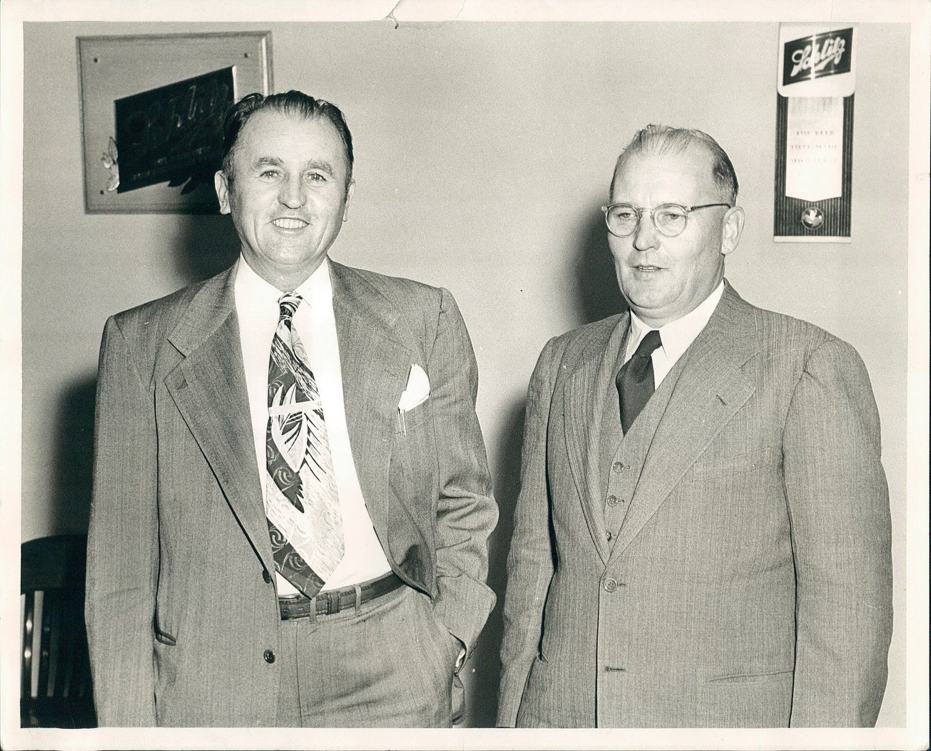 Two men in suits and ties are standing next to each other