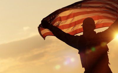Naval Officer holding up the American flag - Garage Door Solutions