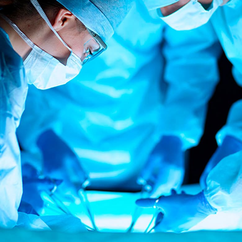 Equipe cirúrgica realizando procedimento coloproctológico