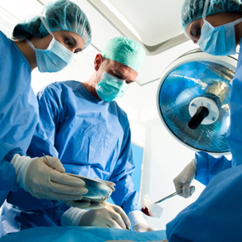 Equipe cirúrgica realizando procedimento de cirurgia do pâncreas em bloco operatório